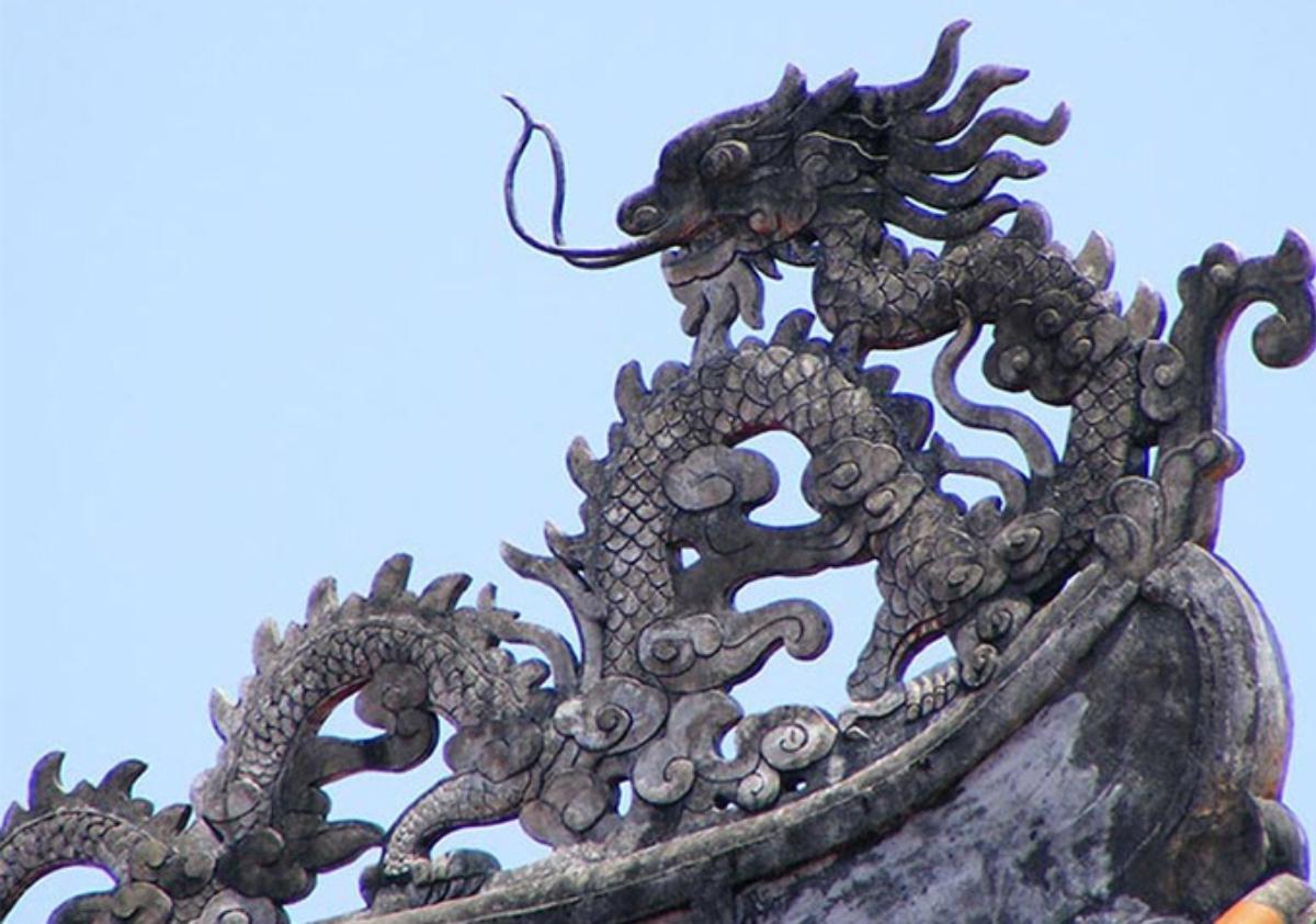 A dragon sculpture on a roof

Description automatically generated