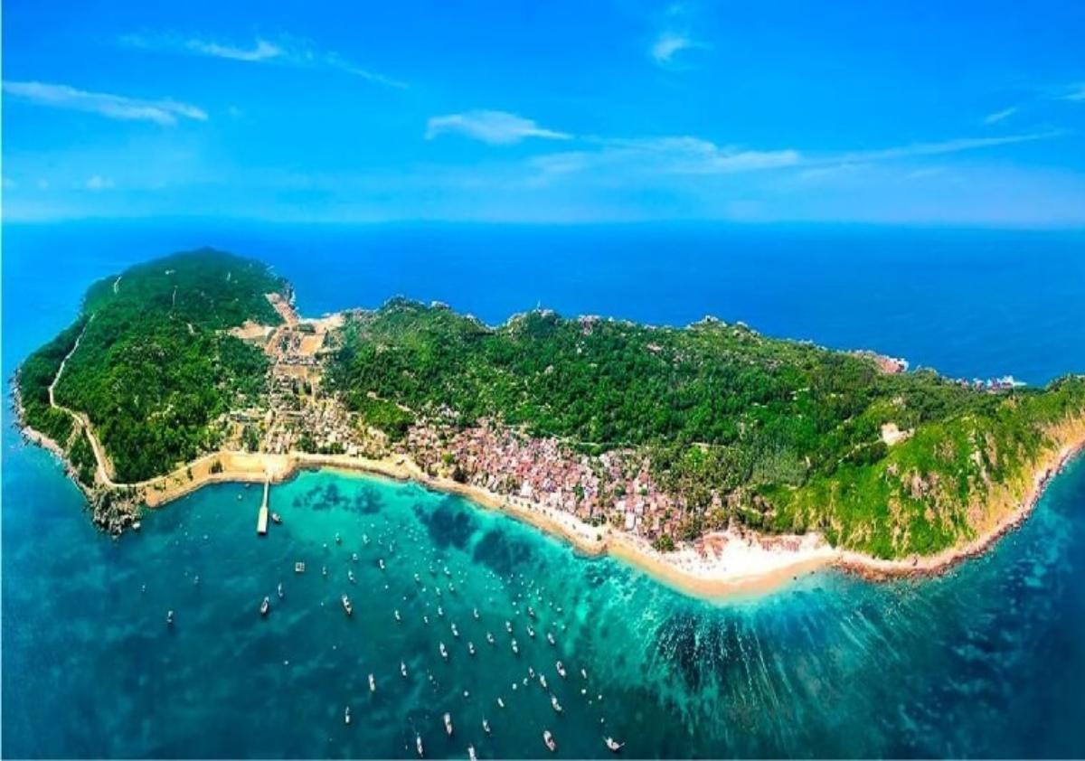 An aerial view of a beach with boats and a body of water

Description automatically generated