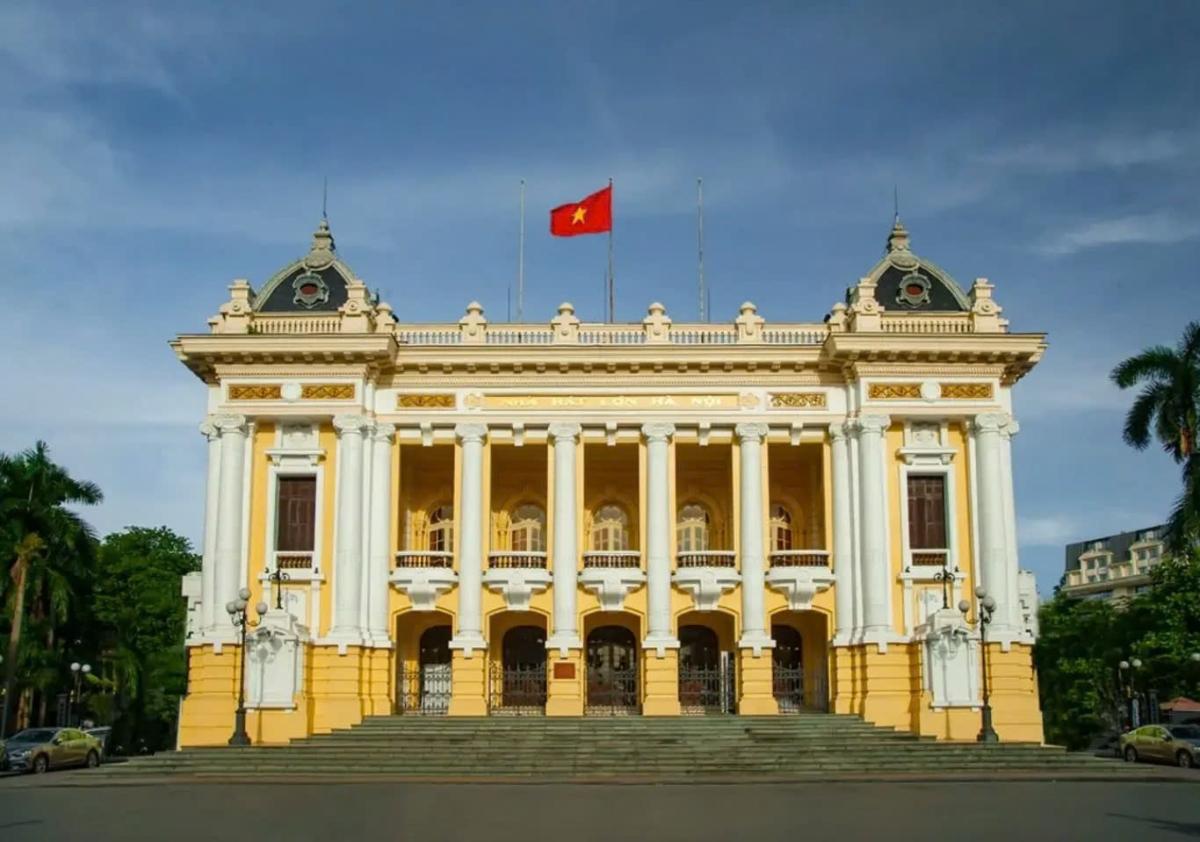 A yellow building with a flag on top

Description automatically generated