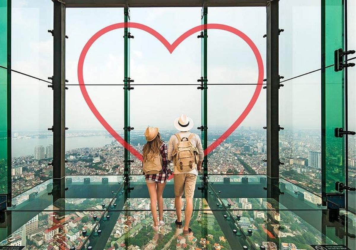 Two people standing on a glass floor looking at a heart

Description automatically generated