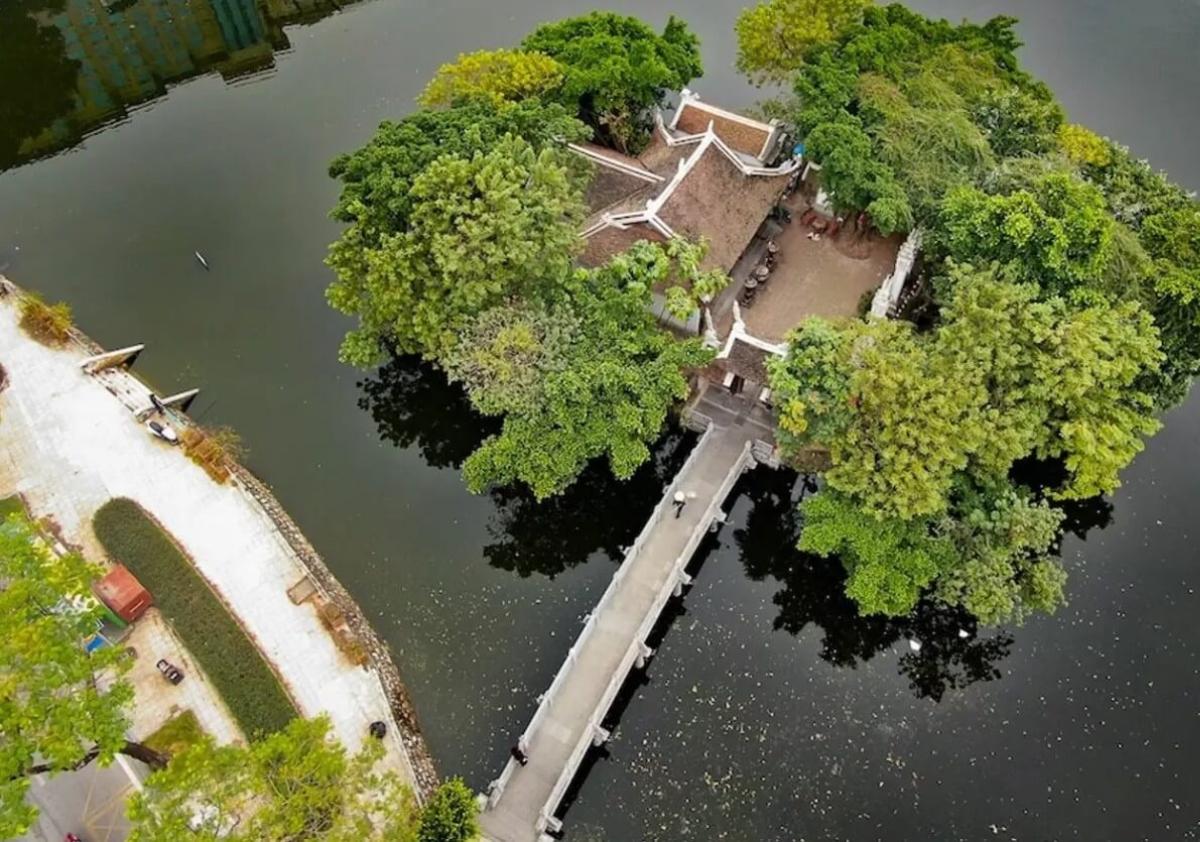 A bridge over a body of water with trees around it

Description automatically generated