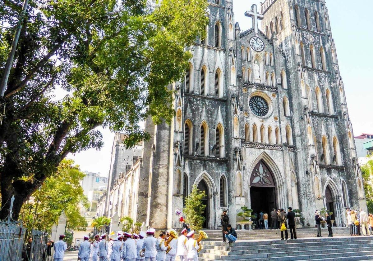 A group of people in white uniforms outside of a church

Description automatically generated